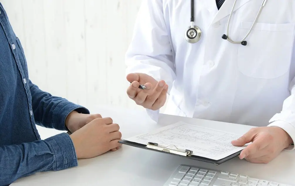 A doctor is talking to someone in front of him.