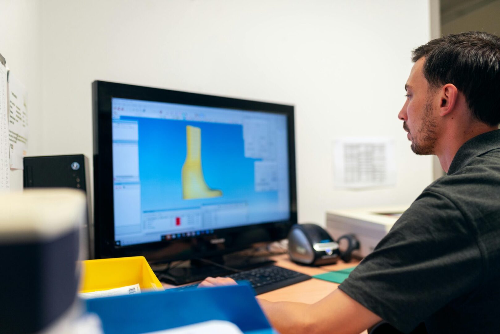 A man sitting at his computer looking at the screen.