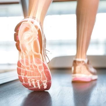 A person is walking on the treadmill in their shoes.